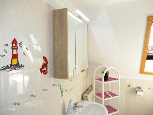 a bathroom with a sink and a mirror at Ferienwohnungen "Marie" mit Terrassen, inclusive Park- und Stellplätze am Haus, Müritz-Strand nur 700m, Altstadt 10min, ruhige Lage, in Waren