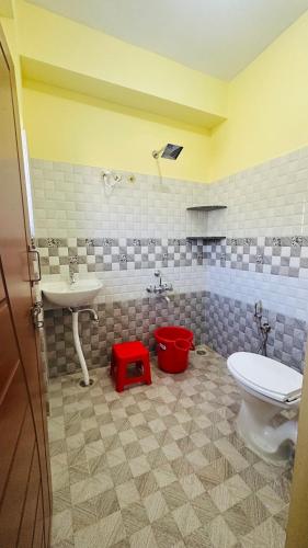 a bathroom with a white toilet and a sink at Navile Apartments in Chikmagalūr