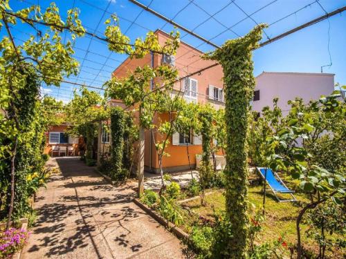 einen Garten vor einem Haus mit Reben in der Unterkunft Apartments Amalia in Zadar