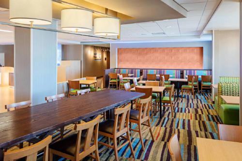 a dining room with a long table and chairs at Fairfield Inn & Suites by Marriott North Bergen in North Bergen