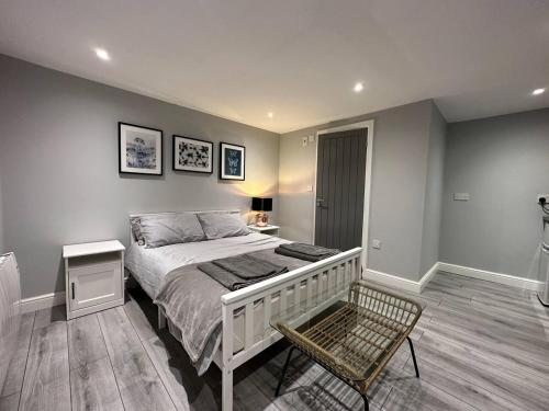 a bedroom with a bed and a chair in it at Luxury Detached Studio Apartment in Luton in Luton
