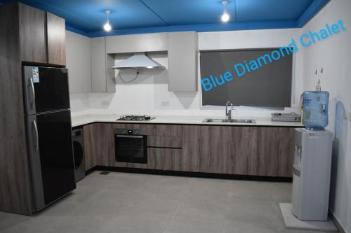 a kitchen with a black refrigerator and a sink at Blue Diamond in Jerash