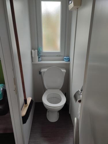Elle comprend une petite salle de bains pourvue de toilettes et d'une fenêtre. dans l'établissement Mobil home, à Port-la-Nouvelle