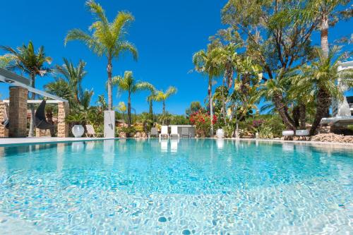 a large swimming pool with palm trees in the background at Villa Heaven in Protaras