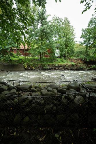 a river with a fence in front of it at Doispe Nuci in Bistra Mureşului