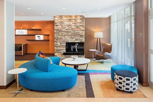 a living room with blue furniture and a fireplace at Fairfield Inn & Suites by Marriott North Bergen in North Bergen