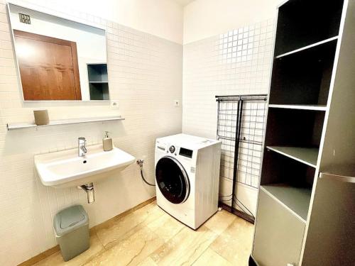 a bathroom with a washing machine and a sink at Entire Apartment, FREE PARKING, City Center 15 Minutes in Prague