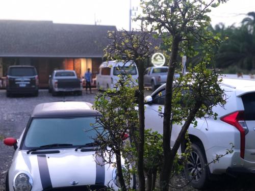 a white car parked next to a tree at กอบสุข รีสอร์ท2 k12 in Ban Ton Liang