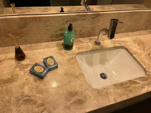 a bathroom sink with soap and a bottle of soap at Flat Meliá BR 21 Suíte de Luxo A308 in Brasilia