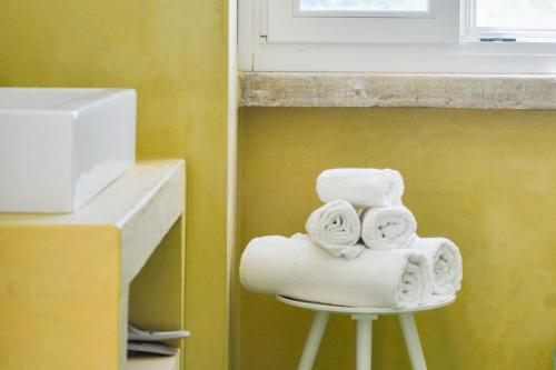 a pile of towels on a stool next to a window at Masseria Torrechiara Eco Dimora di Charme in Castel del Monte