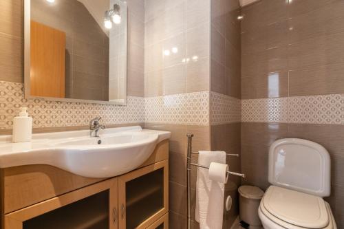 een badkamer met een wastafel en een toilet bij Villa Amarela by AlgarveManta in Manta Rota
