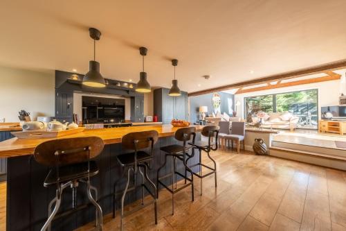 a kitchen with a large island with bar stools at Heath Cottage in Mattishall
