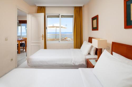 ミハス・コスタにあるPueblo Marina Seaside Apartaments by Alfresco Staysのベッド2台が備わる海の景色を望むホテルルームです。