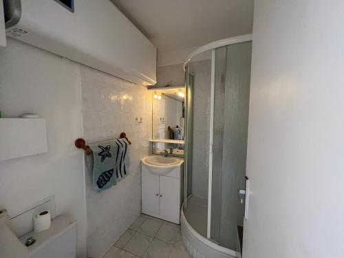 une salle de bain avec un lavabo, des toilettes et un miroir dans l'établissement 4 personnes au Village de la mer, à La Londe-les-Maures