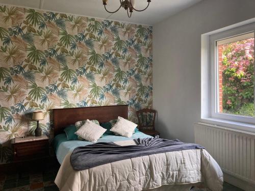 een slaapkamer met een bed met tropisch behang bij La Grange aux Tommies - Pays du Coquelicot in Bus Les Artois