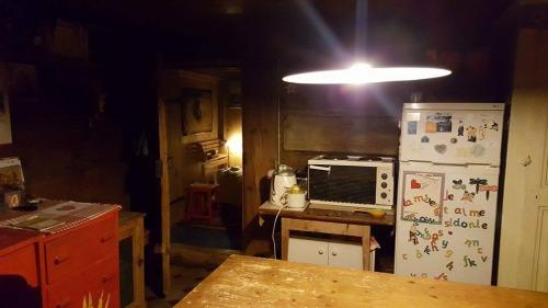 a kitchen with a refrigerator and a table and a light at L'Étoile Enchantée in Ciernes-Picat