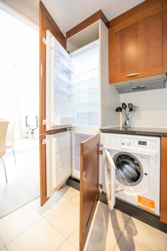 a kitchen with a washing machine in a kitchen at Grand Canal Square Apartments in Dublin