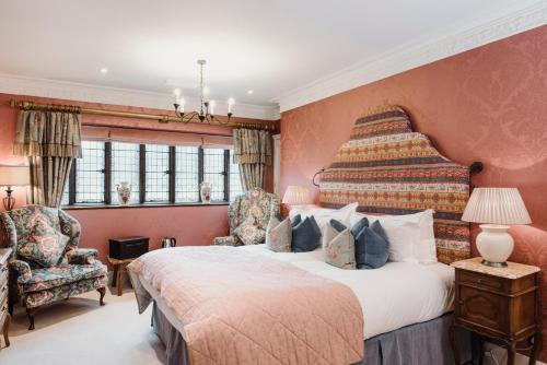 a bedroom with a large bed and two chairs at Hever Castle Luxury Bed and Breakfast in Edenbridge