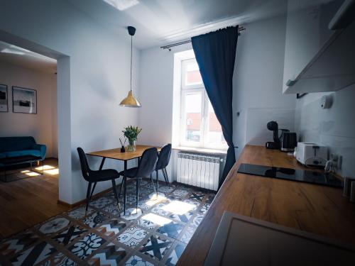 un soggiorno con tavolo, sedie e finestra di Black&White Apartment 8 a Katowice