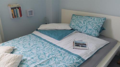 a bed with a book sitting on top of it at BED & BREAKFAST für Individualisten in Gemeinde Scharbeutz, auch Allergiker in Scharbeutz