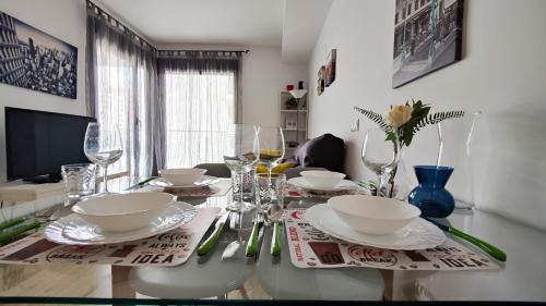 una mesa de comedor con platos y vasos. en CALA ALTA sun&beach apartaments, en Cala de Finestrat