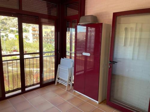 a room with a red door and a chair on a balcony at NATUR Spa in Villanueva de Río Segura
