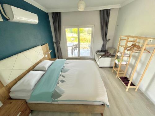um quarto com uma cama grande e uma janela em Airport Guest House em Dalaman