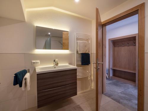 a bathroom with a sink and a mirror at Ferienwohnung Waldesruh in Kössen