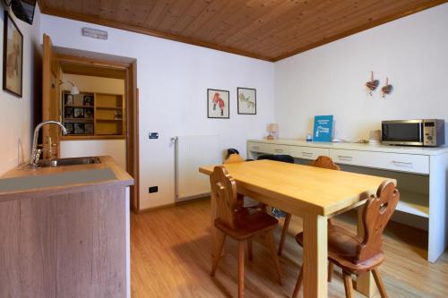 cocina con mesa de madera y fregadero en Casa Cadore en Lozzo Cadore