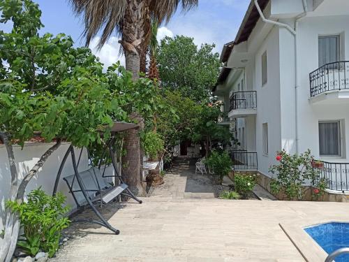 um pátio de uma casa com uma palmeira em Işıl Suit Apart Otel em Dalyan