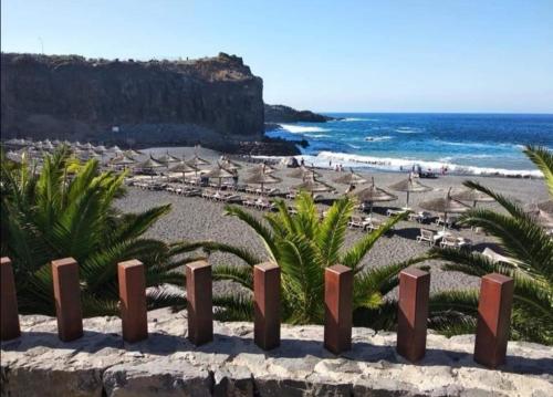 a beach with umbrellas and chairs and the ocean at Stunning Sea View FREE WIFI in Callao Salvaje
