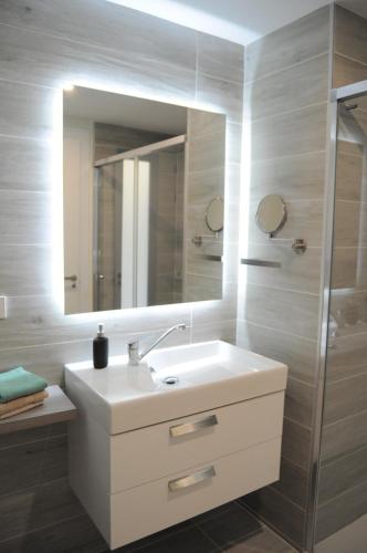 een badkamer met een witte wastafel en een spiegel bij Apartamento Vanian Gardens Estepona in Estepona