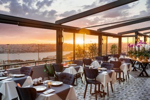 a restaurant with tables and chairs with a view at Rixos Pera Istanbul in Istanbul