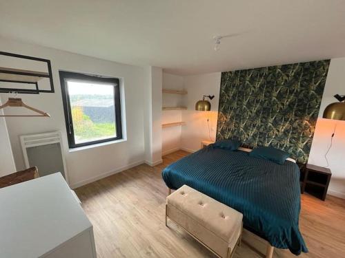 um quarto com uma cama azul e uma janela em Gîte dans un hameau breton - 10 personnes 