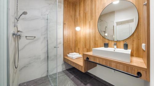 a bathroom with a sink and a mirror at Apartamenty Magnet Jantaris in Mielno