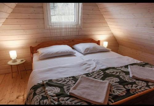 ein Schlafzimmer mit einem großen Bett in einem Holzzimmer in der Unterkunft Domki u Tutki in Szklarska Poręba