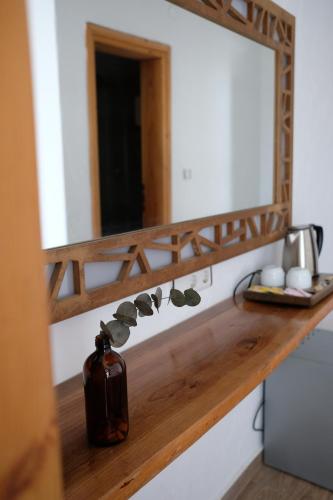 a mirror on a counter with a bottle on it at Ceneviz Hotel in Adrasan