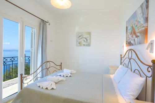 a bedroom with a bed with a view of the ocean at Villa Kalithea in Nisaki