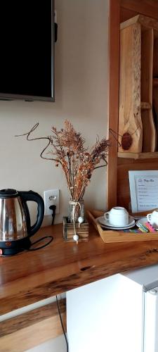 a wooden counter with a television and a vase with flowers at Pousada Sentiero in Urubici
