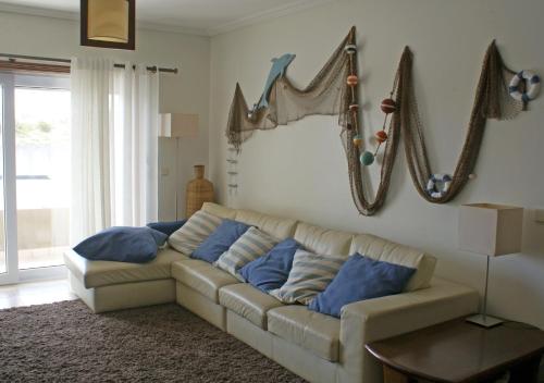 a living room with a couch with blue pillows at Barra Azul in Praia da Barra