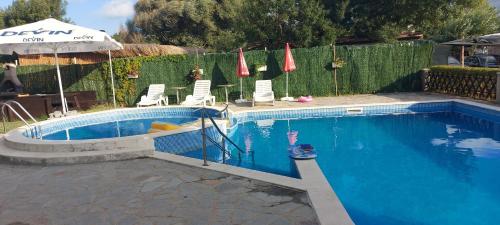 una piscina con sedie e ombrelloni accanto a una recinzione di Oasis Beach Home Four a Lozenets