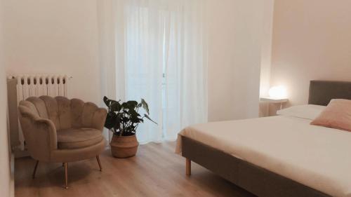um quarto com uma cama, uma cadeira e uma planta em So Fine Petruzzelli flat em Bari