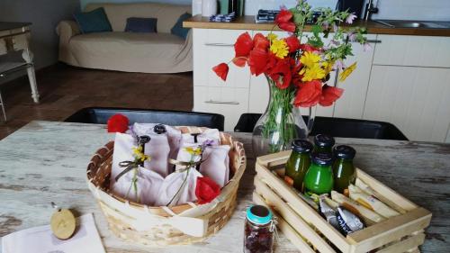 Agriturismo Casale San Benedetto في Ceri: طاولة مع سلالتين و مزهرية مع الزهور