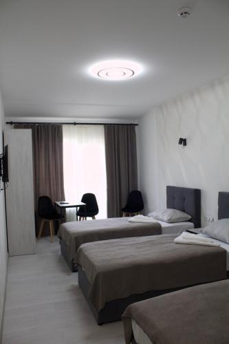 a hotel room with three beds and a table at Forsage Hotel in Uzhhorod