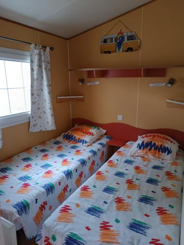 deux lits côte à côte dans une chambre dans l'établissement Mobil home 6 personnes climatisation Sainte Croix du Verdon - Gorges du Verdon, à Sainte-Croix-de-Verdon