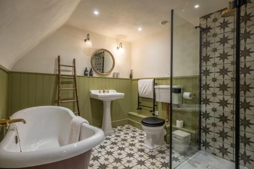 a bathroom with a tub and a sink and a shower at Hensill Farmhouse in Hawkhurst
