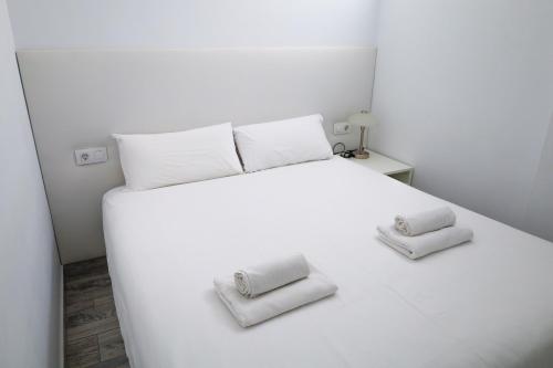 a white bed with two towels on top of it at Lovely Sea View FREE WIFI in Adeje