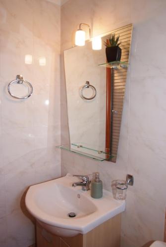La salle de bains est pourvue d'un lavabo et d'un miroir. dans l'établissement Τακης, à Xiropigado
