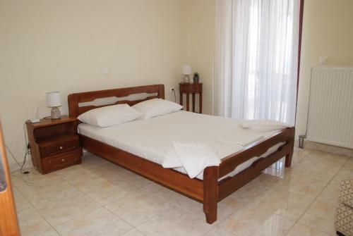 a bedroom with a bed with white sheets and pillows at Τακης in Xiropigado