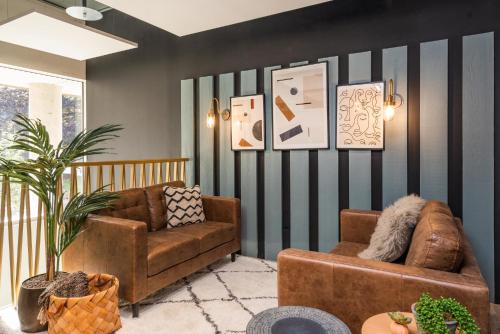 a living room with two couches and a striped wall at Studios and Ensuites with Shared Kitchen at Hillfort House in Brighton in Brighton & Hove